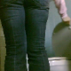 A hidden camera set up in a bathroom records a woman peeing while sitting on a toilet and then wiping herself. There is audio, but not very loud.